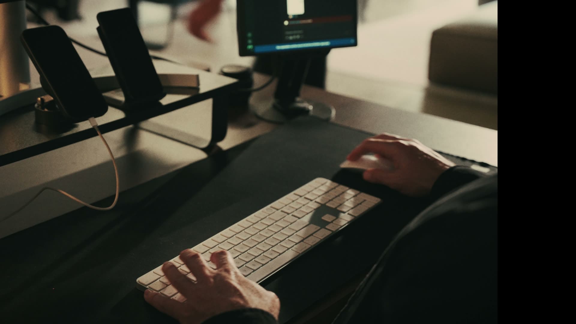 Hands typing at a desk while working on AI product development
