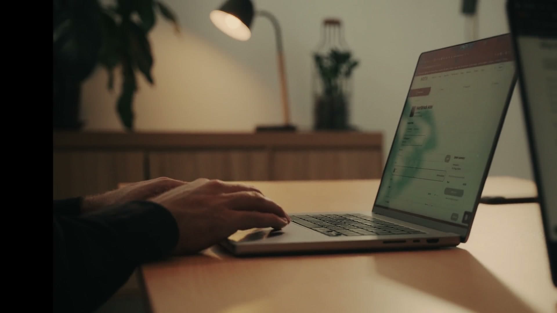 Hands typing on an open laptop showing a website
